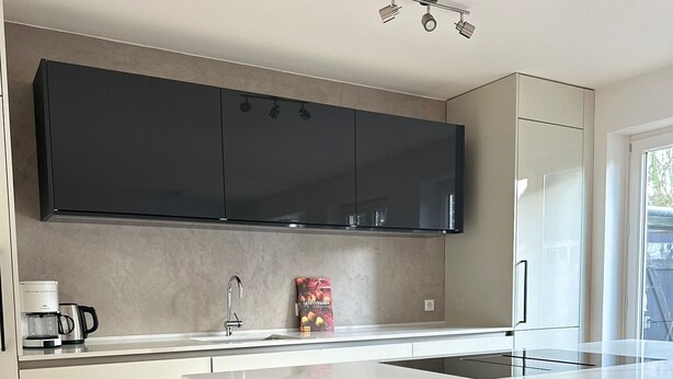 A modern kitchen with a large island, dark cabinets, and a coffee maker. - Entire accommodation "Historisches Nottuln", Baumberge - near Münster (Nottuln)