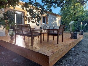 Enjoy outdoor dining or relaxation on the deck with comfortable seating and a small table.
