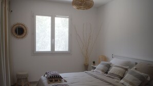 A bedroom with a bed, bedside tables, a window, and a hanging light fixture. - Detached villa, Swimming pool, Spa, Garden furniture. Near Vallon Pont d'Arc. (Labastide-de-Virac)
