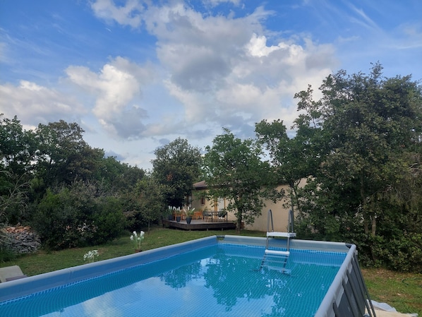 Relax by the serene pool surrounded by lush greenery and trees.