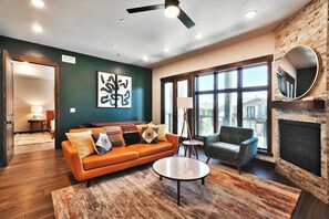 A modern living room with a leather sofa, a round coffee table, and a fireplace.