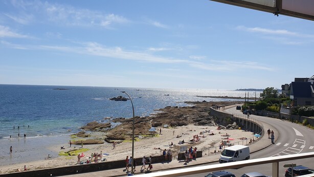 Une vue côtière avec une plage, une côte rocheuse et une route qui serpente le long de la côte.