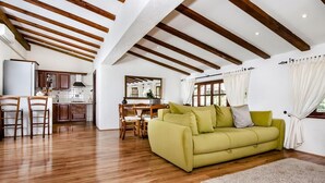 A spacious living area with wooden flooring, a green sofa, and a dining table with chairs. - House 2041/31790 (Istria - Rovinj), 1000m from the beach (Rovinj)