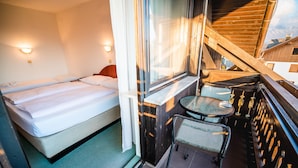 Una habitación de hotel con una cama, una mesita y una silla.