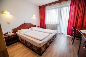 Une chambre d’hôtel comprenant un lit, des tables de chevet, un bureau et une chaise.