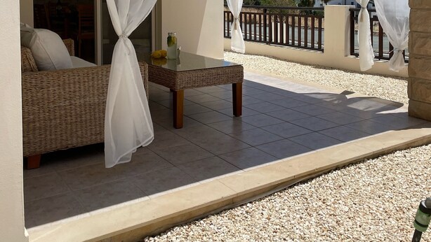 A balcony with a wicker sofa and a glass table, covered by sheer white curtains. - Villa Denis, heated pool on request, centrally located in Coral Bay (Coral Bay)