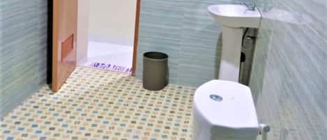 A small bathroom with a toilet, sink, and trash can.