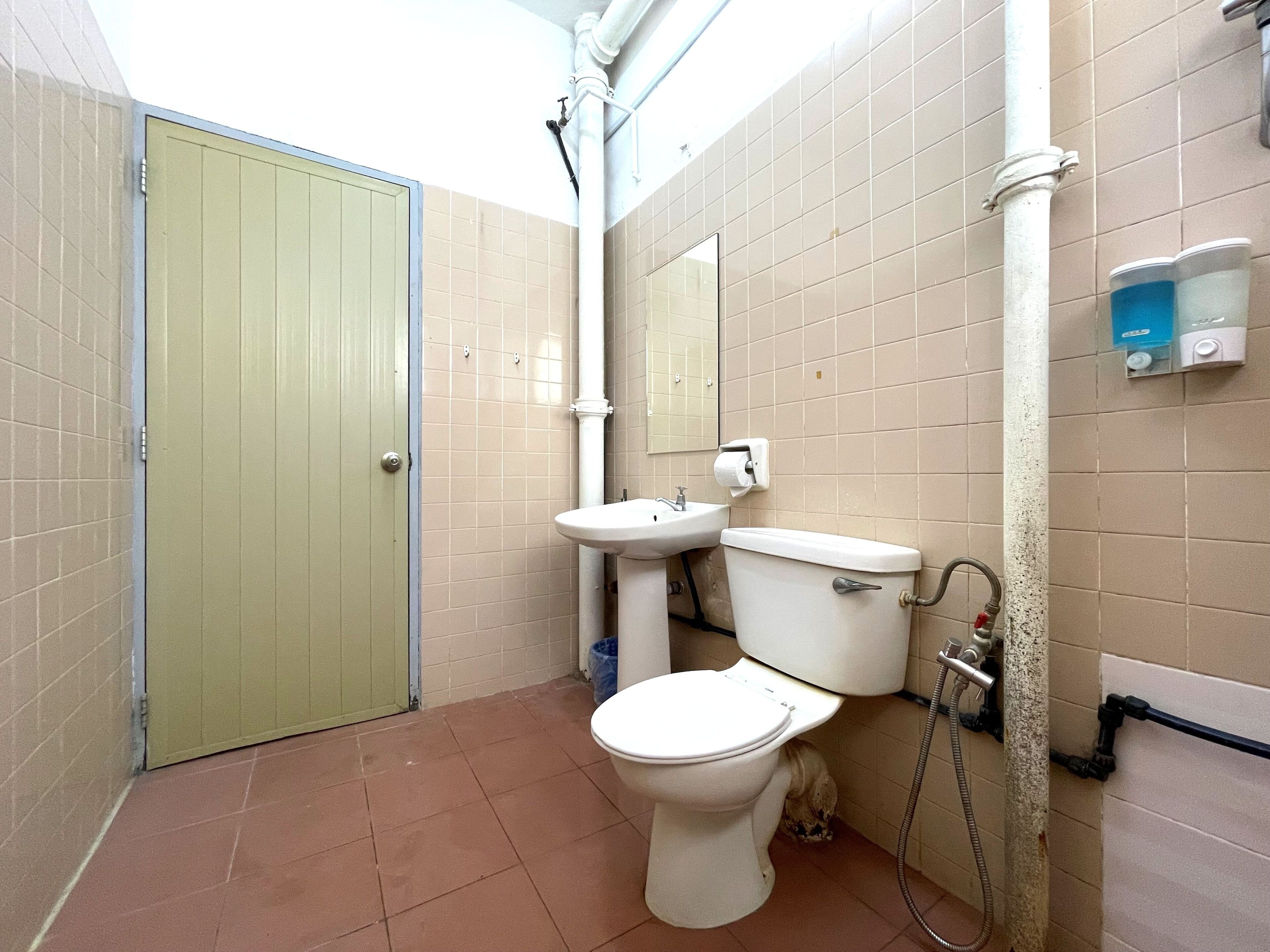 A small bathroom with a toilet, sink, and shower.