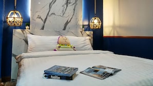 A hotel room with a marble headboard, two hanging lamps, a plush toy, and a couple of magazines on the bed. - @Saphan Pla Bangkok (Bangkok)