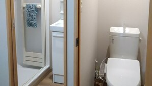 Un baño con inodoro, lavabo y ducha.