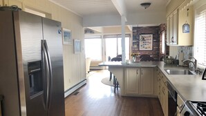 Een moderne keuken met houten vloeren, roestvrijstalen apparatuur en een centraal kookeiland.