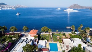 A coastal hotel with a swimming pool, sun loungers, and a view of the sea with yachts. - Marin Yalıkavak Hotel (Bodrum)