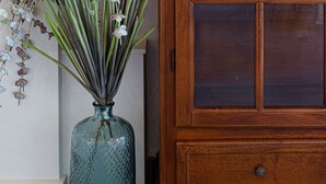A wooden cabinet with glass doors and a vase with flowers. - Kismet Apt - Retreat to a Stylish home (Chania)