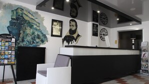 A reception area with a reception desk, a framed portrait, a clock, and a wall-mounted painting. - Sampiero Corso (Corte)