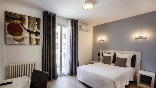 A modern bedroom with a large bed, a chair, a table, and a painting on the wall. - Sampiero Corso (Corte)