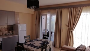 A compact living space with a dining area, kitchenette, and a sofa. - Eugenia Studios (Kefalonia)