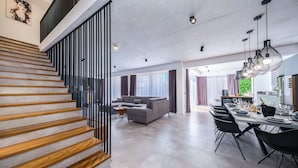 A modern living space with a staircase, a sofa set, a dining area, and a kitchen. - Villa Antonia (Kastela)