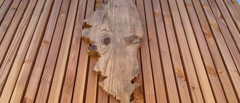 A wooden structure with vertical planks and a central carved wooden piece.