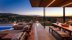 Eine Terrasse im Freien mit Holzmöbeln, einem Pool und Blick auf die Landschaft.