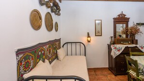 A bedroom with a bed, a wooden dresser, a mirror, and various decorative items on the wall. -  Eros Cozy, Panoramic Sea View, Perfect Location (Pylos-Nestoras)