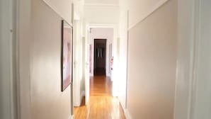 A narrow hallway with wooden flooring and white walls. - Rivoli Cinema Hostel (Porto)
