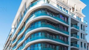 Un hôtel à plusieurs étages, doté de balcons incurvés et de grandes fenêtres.
