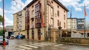 A building with multiple floors, a sign indicating a restaurant, and a pedestrian crossing. - OYO Hotel Restaurante La Pinta (Ampuero)