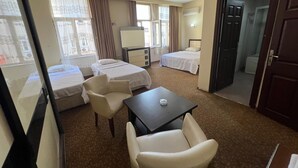 A hotel room with two beds, a desk, a chair, and a window. - Grand Adanus Hotel (Adana)