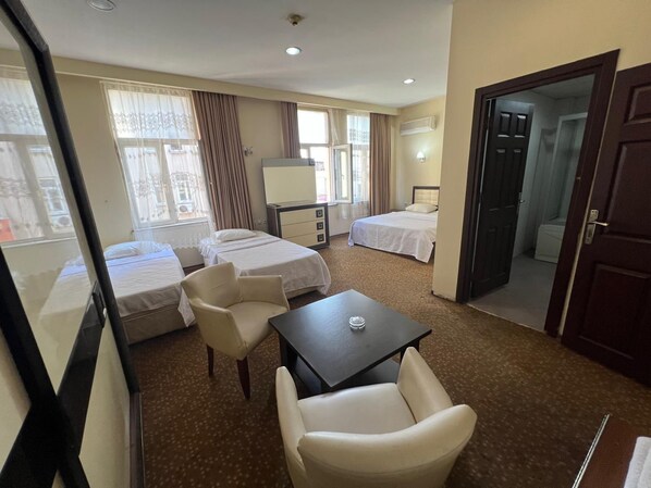 A hotel room with two beds, a desk, a chair, and a window. - Grand Adanus Hotel (Adana)