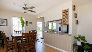 Eine geräumige Küche mit Essbereich, Holzmöbeln und Deckenventilator.