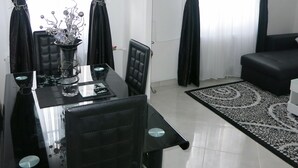 A dining area with a black table and chairs, a vase with decorative items, and black curtains on the windows. - Building part of the city's heritage (Joinville-le-Pont)