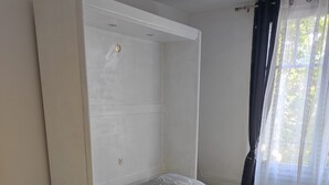 A bedroom with a bed, a nightstand, a lamp, and a patterned rug. - Building part of the city's heritage (Joinville-le-Pont)