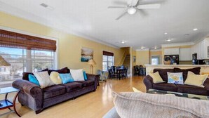 A spacious living area with two sofas, a coffee table, and a dining area with chairs.