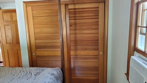 Un dormitorio con cama, armario de madera y radiador.