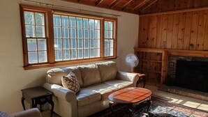 Una sala de estar acogedora con un sofá de cuero, una mesita y una chimenea.