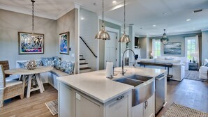 A modern kitchen with a central island, stainless steel appliances, and pendant lighting.