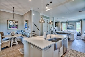 A modern kitchen with a central island, stainless steel appliances, and pendant lighting.