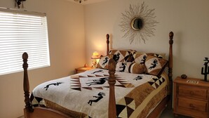 Un dormitorio con cama con dosel, un adorno de sol en la pared y una mesita de noche con lámpara.