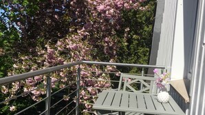 A balcony with a metal railing, a table, and chairs. - Vacation apartment directly on the Ems dyke in an idyllic location (Westoverledingen)