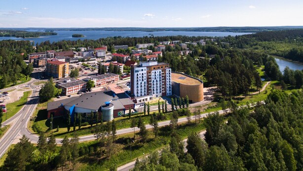 An aerial view of a town with buildings, roads, and a lake. - Hotelli Kuohu (Kangasala)