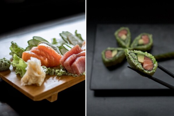 A sushi platter with salmon, cucumber, and avocado on a wooden board.