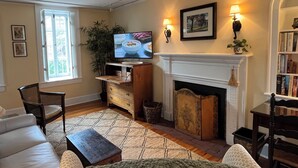 A living room with a fireplace, a television, and a bookshelf. - The Castle - c. 1780 (Lexington)