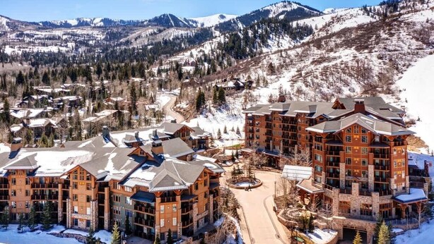 A large lodge with multiple buildings, a central courtyard, and a mountainous backdrop. - Abode at Alpine Penthouse, ski-in/ski-out, sauna, pool & gym (Park City)