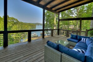 A covered outdoor deck with a view of a lake and forest. - Lake Blue Ridge Cabin Sleeps 10 with Private Dock! (Blue Ridge)