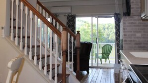 Una escalera con balaustradas de madera que conduce a un balcón con vistas a zonas verdes.