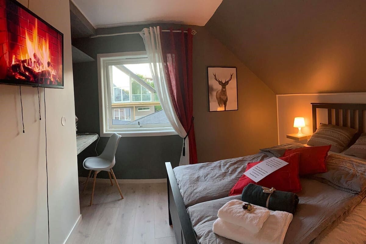 A bedroom with a bed, a desk, and a chair.