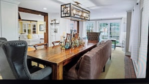 A dining area with a long wooden table, cushioned benches, and a chandelier. - 22 minutes to Foxboro - FIFA GAMES 20 MINUTE AWAY - SLEEPS 10, FITNESS AND SPA (Milton)