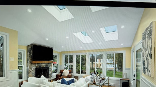 A spacious living room with a fireplace, comfortable seating, and large windows offering views of the outdoors. - 22 minutes to Foxboro - FIFA GAMES 20 MINUTE AWAY - SLEEPS 10, FITNESS AND SPA (Milton)