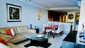 Una sala de estar moderna con sofá, mesa de centro y comedor.