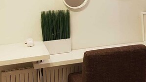 Un comedor con una mesa blanca, tres espejos en la pared y una planta en maceta.